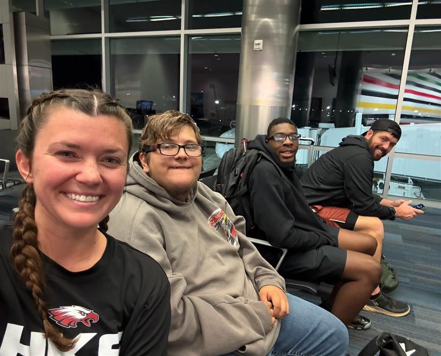  George and Tierece smile at the camera with Coach Mallory Corbitt and Brandon Rogers at the airport